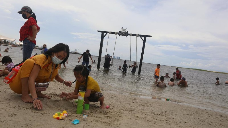 Wisatawan menikmati suasana Pantai Lagoon, Ancol, Jakarta, Jumat (30/10/2020). Libur Nasional dan Cuti bersama dimanfaatkan warga Jakarta untuk bertamasya ke tempat wisata di Jakarta.  (CNBC Indonesia/Andrean Kristianto)
