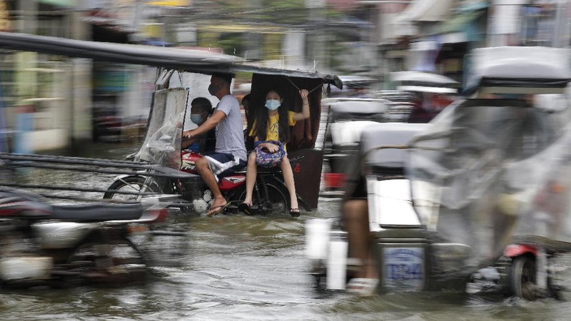In this photo provided by the Philippine Coast Guard, families are evacuated to safer ground in Camarines Sur province, eastern Philippines on Saturday Oct. 31, 2020 as they prepare for typhoon Goni. Families living near coastal towns have started moving to evacuation centers as the strong typhoon approaches the country. (Philippine Coast Guard via AP)
