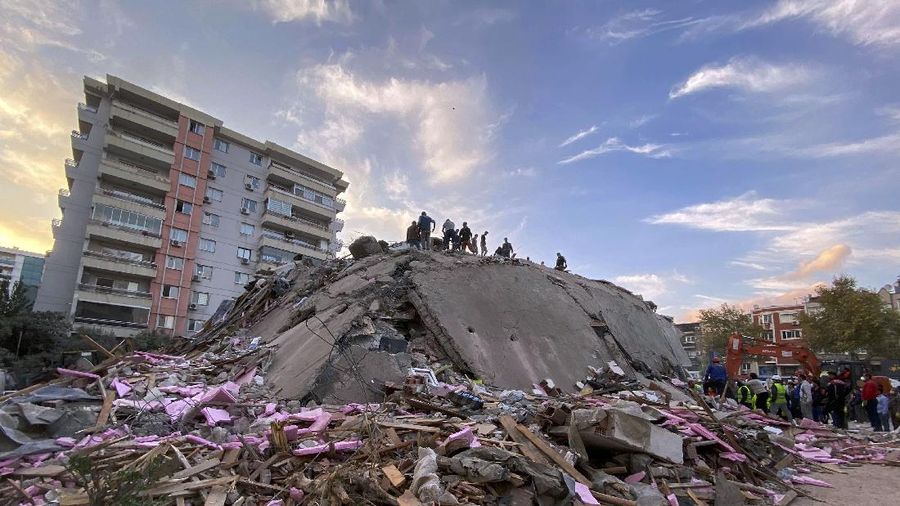 Rescue workers try to save people trapped in the debris of a collapsed building, in Izmir, Turkey, Friday, Oct. 30, 2020. A strong earthquake struck Friday in the Aegean Sea between the Turkish coast and the Greek island of Samos, killing several people and injuring hundreds amid collapsed buildings and flooding, officials said.(AP Photo/Ismail Gokmen)