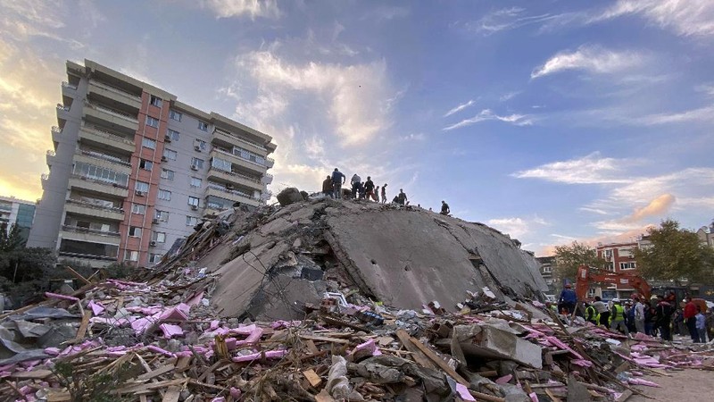 Rescue workers try to save people trapped in the debris of a collapsed building, in Izmir, Turkey, Friday, Oct. 30, 2020. A strong earthquake struck Friday in the Aegean Sea between the Turkish coast and the Greek island of Samos, killing several people and injuring hundreds amid collapsed buildings and flooding, officials said.(AP Photo/Ismail Gokmen)