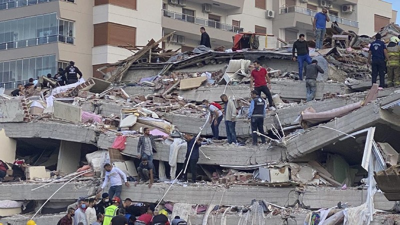 Rescue workers try to save people trapped in the debris of a collapsed building, in Izmir, Turkey, Friday, Oct. 30, 2020. A strong earthquake struck Friday in the Aegean Sea between the Turkish coast and the Greek island of Samos, killing several people and injuring hundreds amid collapsed buildings and flooding, officials said.(AP Photo/Ismail Gokmen)