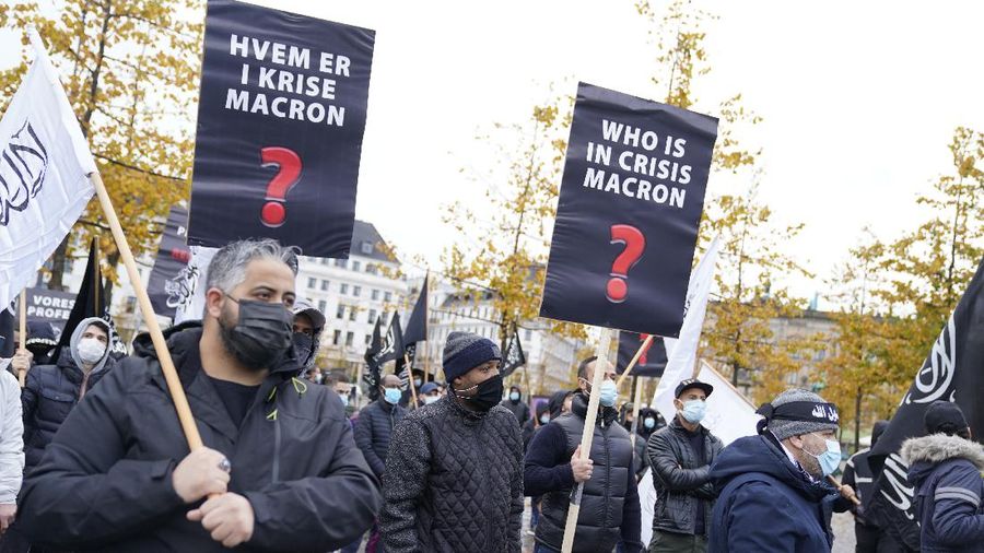 A protester wearing a face mask outside the French embassy in London, Friday, Oct. 30, 2020, to protest against French President Macron. Protesters are upset over the publication of pictures and what they see as disrespect of the Prophet Muhammad, in the wake of the terror attack in Nice, France. (AP Photo/Frank Augstein)