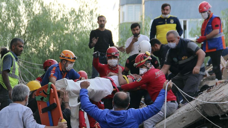 Rescue workers try to save people trapped in the debris of a collapsed building, in Izmir, Turkey, Friday, Oct. 30, 2020. A strong earthquake struck Friday in the Aegean Sea between the Turkish coast and the Greek island of Samos, killing several people and injuring hundreds amid collapsed buildings and flooding, officials said.(AP Photo/Ismail Gokmen)