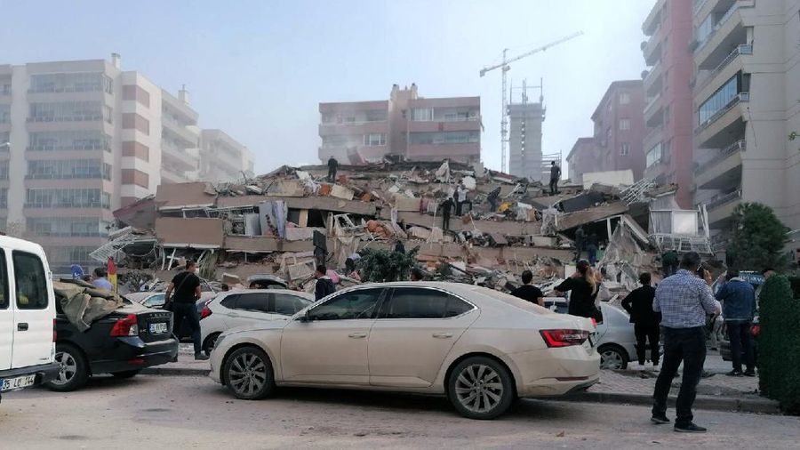 Rescue workers try to save people trapped in the debris of a collapsed building, in Izmir, Turkey, Friday, Oct. 30, 2020. A strong earthquake struck Friday in the Aegean Sea between the Turkish coast and the Greek island of Samos, killing several people and injuring hundreds amid collapsed buildings and flooding, officials said.(AP Photo/Ismail Gokmen)