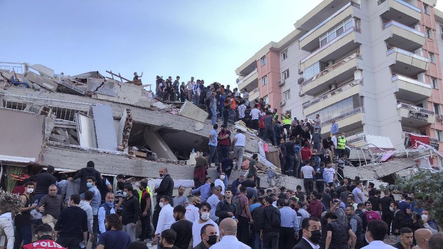 Rescue workers try to save people trapped in the debris of a collapsed building, in Izmir, Turkey, Friday, Oct. 30, 2020. A strong earthquake struck Friday in the Aegean Sea between the Turkish coast and the Greek island of Samos, killing several people and injuring hundreds amid collapsed buildings and flooding, officials said.(AP Photo/Ismail Gokmen)