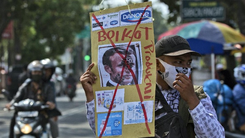 A protester wearing a face mask outside the French embassy in London, Friday, Oct. 30, 2020, to protest against French President Macron. Protesters are upset over the publication of pictures and what they see as disrespect of the Prophet Muhammad, in the wake of the terror attack in Nice, France. (AP Photo/Frank Augstein)