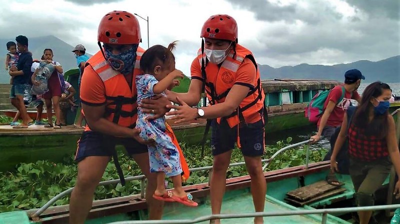 In this photo provided by the Philippine Coast Guard, families are evacuated to safer ground in Camarines Sur province, eastern Philippines on Saturday Oct. 31, 2020 as they prepare for typhoon Goni. Families living near coastal towns have started moving to evacuation centers as the strong typhoon approaches the country. (Philippine Coast Guard via AP)