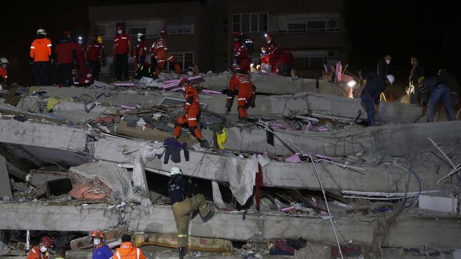 Members of rescue services search in the debris of a collapsed building for survivors in Izmir, Turkey, early Saturday, Oct. 31, 2020. A strong earthquake struck Friday in the Aegean Sea between the Turkish coast and the Greek island of Samos, killing several people and injuring hundreds amid collapsed buildings and flooding. (AP Photo/Emrah Gurel)