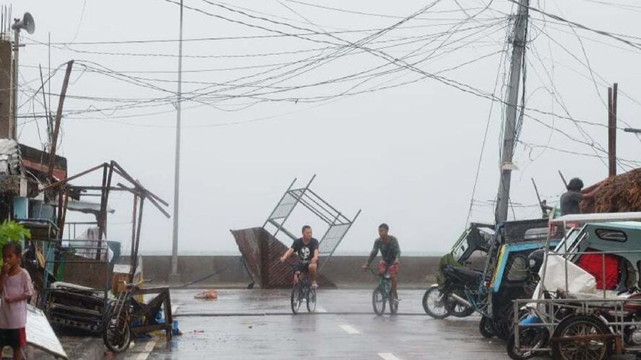 Residents walk past a toppled structure as waves batter the coast of Sorsogon province, central Philippines as Typhoon Goni hits the country on Sunday, Nov. 1, 2020. A super typhoon slammed into the eastern Philippines with ferocious winds early Sunday and about a million people have been evacuated in its projected path, including in the capital where the main international airport was ordered closed. (AP Photo)