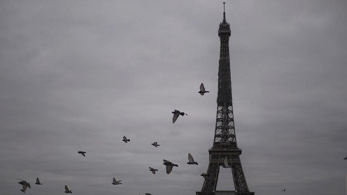 APTOPIX Virus Outbreak France Pigeons fly next to the Eiffel Tower in Paris, Friday, Oct. 30, 2020. France re-imposed a monthlong nationwide lockdown Friday aimed at slowing the spread of the virus, closing all non-essential business and forbidding people from going beyond one kilometer from their homes except to go to school or a few other essential reasons. (AP Photo/Thibault Camus)