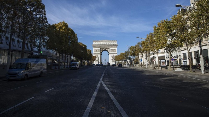 Pigeons fly next to the Eiffel Tower in Paris, Friday, Oct. 30, 2020. France re-imposed a monthlong nationwide lockdown Friday aimed at slowing the spread of the virus, closing all non-essential business and forbidding people from going beyond one kilometer from their homes except to go to school or a few other essential reasons. (AP Photo/Thibault Camus)