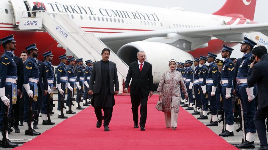 Turkey's President Recep Tayyip Erdogan, center, and Pakistan Prime Minister Imran Khan review a military honour guard during a welcome ceremony at Nur Khan airbase, in Rawalpindi, Pakistan, Thursday, Feb. 13, 2020. Erdogan is in Pakistan for a two-day state visit. Erdogan's wife Emine Erdogan is at the right.(Presidential Press Service via AP, Pool)