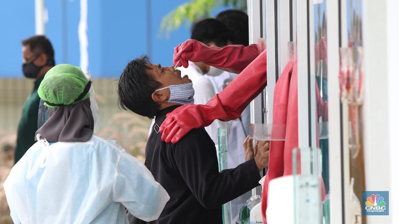 A worker sprays a colleague with disinfectant after a burial of someone who presumably died of the coronavirus at a cemetery in Medan, North Sumatra, Indonesia, Tuesday, Nov. 24, 2020.(AP Photo/Binsar Bakkara)
