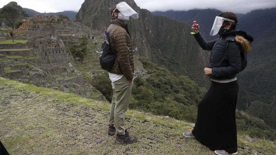 Tourists visit the world-renowned Incan citadel of Machu Picchu as it reopens for the first time since its 8-months-long closure to help curb the spread of COVID-19, in the department of Cusco, Peru, Sunday, Nov. 1, 2020. (AP Photo/Martin Mejia)