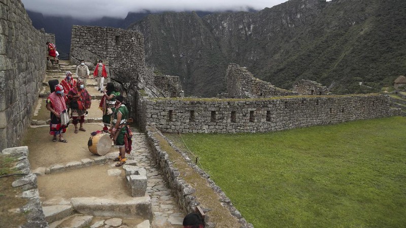 Tourists visit the world-renowned Incan citadel of Machu Picchu as it reopens for the first time since its 8-months-long closure to help curb the spread of COVID-19, in the department of Cusco, Peru, Sunday, Nov. 1, 2020. (AP Photo/Martin Mejia)
