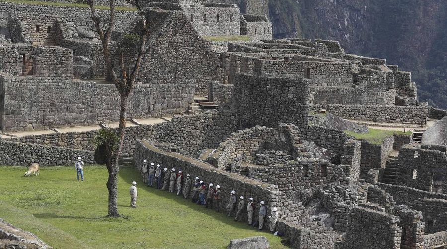 Tourists visit the world-renowned Incan citadel of Machu Picchu as it reopens for the first time since its 8-months-long closure to help curb the spread of COVID-19, in the department of Cusco, Peru, Sunday, Nov. 1, 2020. (AP Photo/Martin Mejia)