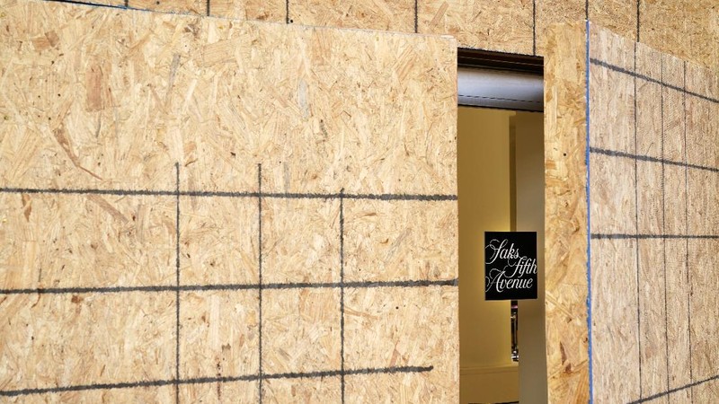Artist Shane Grammar paints a portrait of Martin Luther King Jr. on the sheets of plywood outside a boarded-up jewelry shop amid worries about potential demonstrations and violent responses to the general election on Monday, Nov. 2, 2020, in Los Angeles. (AP Photo/Jae C. Hong)
