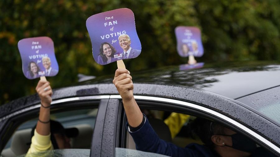 Biden supporters hold up fans during a