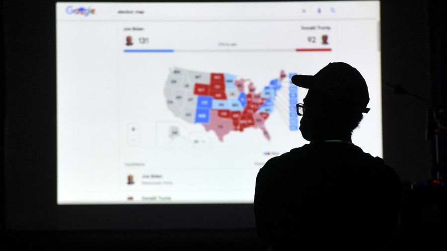A man watches results come in on a screen set up at an election night gathering at Independence Mall , Tuesday, Nov. 3, 2020, in Philadelphia. (AP Photo/Michael Perez)