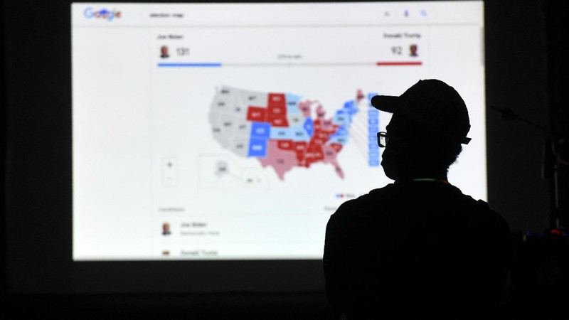 A man watches results come in on a screen set up at an election night gathering at Independence Mall , Tuesday, Nov. 3, 2020, in Philadelphia. (AP Photo/Michael Perez)
