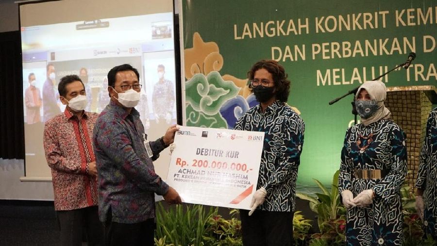 Direktur Hubungan Kelembagaan BNI Sis Apik Wijayanto (kedua kiri) menyerahkan secara simbolis Kredit Usaha Rakyat (KUR) kepada pelaku UMKM binaan Kementerian Perdagangan di Cirebon, Jawa Barat, Kamis (5 November 2020). Penyerahan tersebut disaksikan oleh Menteri Perdagangan RI Agus Suparmanto (kiri). BNI dan Kemendag bekerja sama untuk mendongkrak ekspor UMKM di antaranya melalui penyaluran KUR dan digitalisasi aplikasi BNI MOVE.