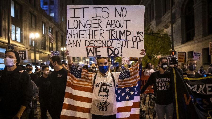 Brittany Bysina holds a sign as demonstrators march through the Loop, demanding every vote be counted in the general election, Wednesday night, Nov. 4, 2020, in Chicago. (Ashlee Rezin Garcia/Chicago Sun-Times via AP)