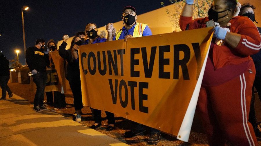 Brittany Bysina holds a sign as demonstrators march through the Loop, demanding every vote be counted in the general election, Wednesday night, Nov. 4, 2020, in Chicago. (Ashlee Rezin Garcia/Chicago Sun-Times via AP)