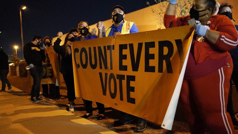 Brittany Bysina holds a sign as demonstrators march through the Loop, demanding every vote be counted in the general election, Wednesday night, Nov. 4, 2020, in Chicago. (Ashlee Rezin Garcia/Chicago Sun-Times via AP)