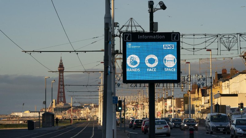 Public information Covid-19 signage is seen before Blackpool's annual Illuminations are lit for the last time before being switched off at midnight on Wednesday because of the four-week lockdown, in Blackpool, England, Wednesday Nov. 4, 2020. The illuminations were due to remain lit for an extra two months this season, until 3 January, to aid the town's tourism trade hit by Covid-19 restrictions. ( AP Photo/Jon Super)