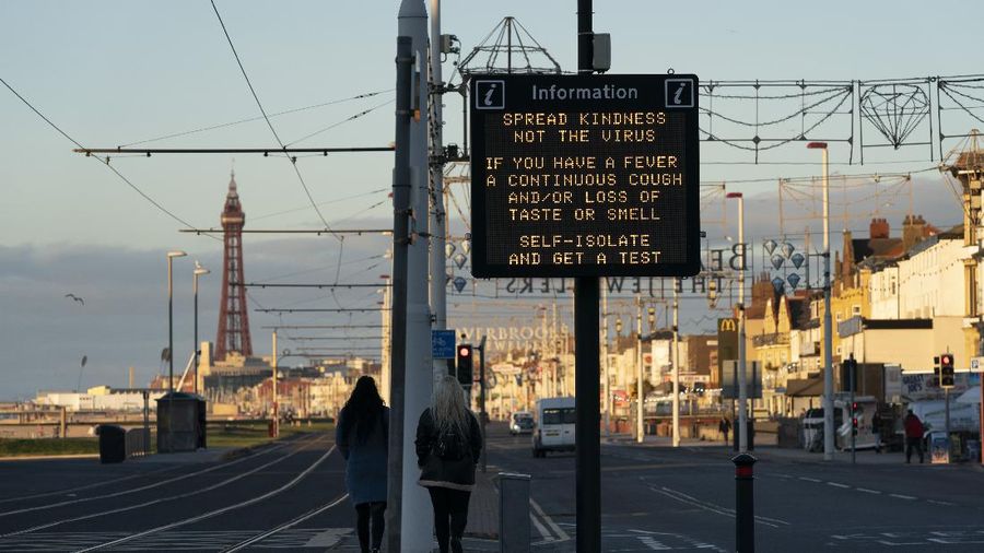 Public information Covid-19 signage is seen before Blackpool's annual Illuminations are lit for the last time before being switched off at midnight on Wednesday because of the four-week lockdown, in Blackpool, England, Wednesday Nov. 4, 2020. The illuminations were due to remain lit for an extra two months this season, until 3 January, to aid the town's tourism trade hit by Covid-19 restrictions. ( AP Photo/Jon Super)