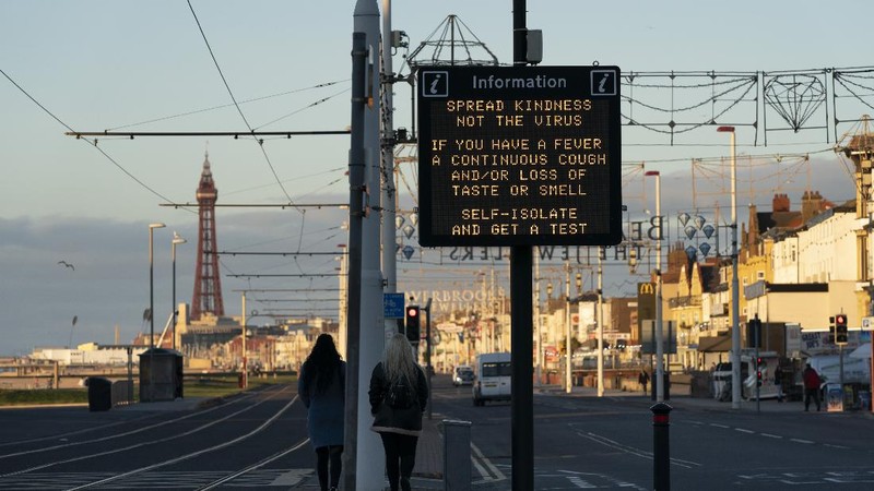 Public information Covid-19 signage is seen before Blackpool's annual Illuminations are lit for the last time before being switched off at midnight on Wednesday because of the four-week lockdown, in Blackpool, England, Wednesday Nov. 4, 2020. The illuminations were due to remain lit for an extra two months this season, until 3 January, to aid the town's tourism trade hit by Covid-19 restrictions. ( AP Photo/Jon Super)
