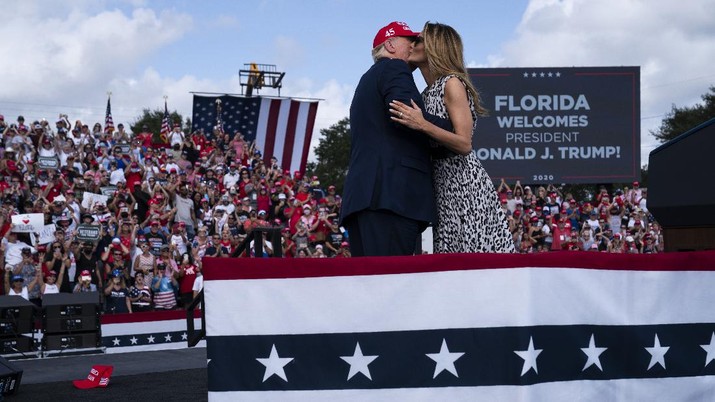 President Donald Trump hugs first lady Melania Trump after she introduced him during a campaign rally outside Raymond James Stadium, Thursday, Oct. 29, 2020, in Tampa. (AP Photo/Evan Vucci)