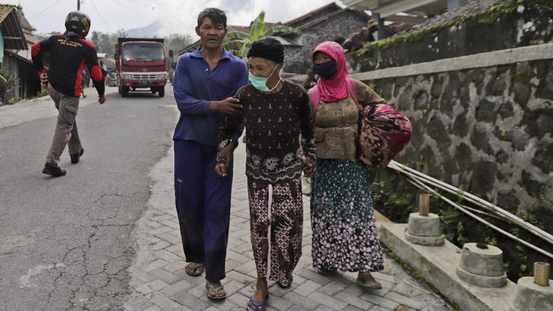Villagers sit on the back of a truck as they are evacuated from their homes on the slope of Mount Merapi, in Krinjing, Central Java, Indonesia, Friday, Nov. 6, 2020. Indonesian authorities began evacuating people living on the volatile volcano's fertile slopes on Friday following an increase in volcanic activity. (AP Photo/Taufiq Rozzaq)