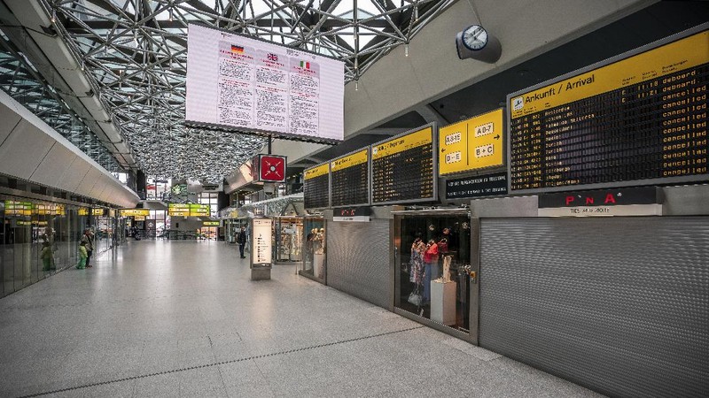 A staff member looks at a departure and arrival information board in an abandoned terminal at the airport Tegel in Berlin, Germany, Monday, June 15, 2020. Borders opened up across Europe on Monday after three months of coronavirus closures that began chaotically in March. But many restrictions persist, it's unclear how keen Europeans will be to travel this summer and the continent is still closed to Americans, Asians and other international tourists. (AP Photo/Michael Sohn)