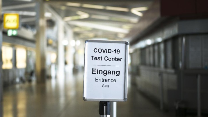 A sign helps passengers to find the COVID-19 test center at the airport Tegel in Berlin, Germany, Saturday, Aug. 8, 2020. From Saturday Aug. 8, on COVID-19 tests are mandatory for passengers coming from a country classified as high risk country. (AP Photo/Markus Schreiber)