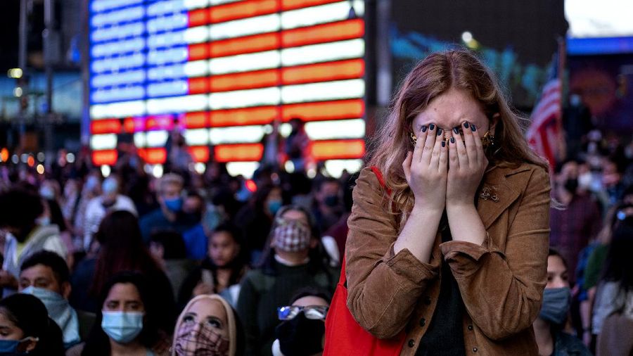 Fletcher Peters of New York, a journalism student at NYU, reacts as she watches President-elect Joe Biden on a monitor in Times Square Saturday, Nov. 7, 2020, in New York, as he addressed the nation. Peters said 