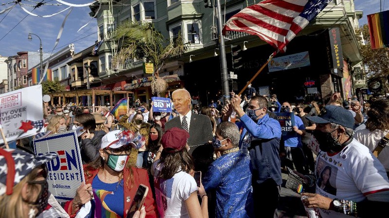 People gather in Black Lives Matter Plaza to celebrate President-elect Joe Biden's win over President Donald Trump to become the 46th president of the United States, Saturday, Nov. 7, 2020, in Washington. His victory came after more than three days of uncertainty as election officials sorted through a surge of mail-in votes that delayed the processing of some ballots. (AP Photo/Jacquelyn Martin)