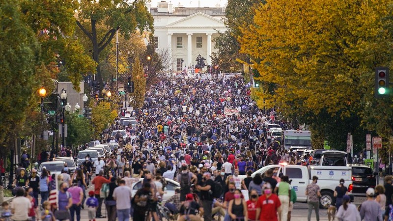 People gather in Black Lives Matter Plaza to celebrate President-elect Joe Biden's win over President Donald Trump to become the 46th president of the United States, Saturday, Nov. 7, 2020, in Washington. His victory came after more than three days of uncertainty as election officials sorted through a surge of mail-in votes that delayed the processing of some ballots. (AP Photo/Jacquelyn Martin)