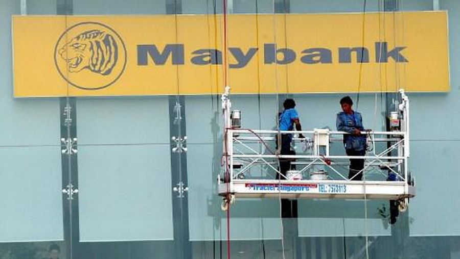A cleaner enjoys the view from a gondola at the Maybank building while his colleague cleans the glass panel in Singapore 10 October 2002. Singapore's economy is estimated to have grown 3.7 percent in the September quarter from the previous year, the government said. AFP PHOTO/Roslan RAHMAN (Photo by ROSLAN RAHMAN / AFP)