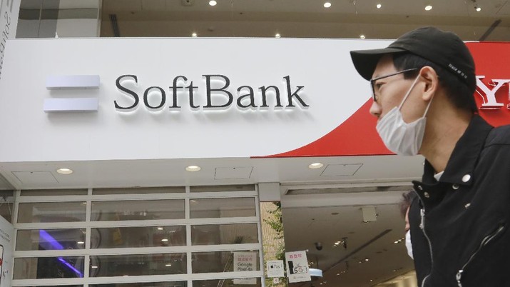 People walk by a SoftBank shop in Tokyo, Monday, Nov. 9, 2020. Japanese technology company SoftBank Group Corp. said Monday it restored its profitability in the last quarter as its investments improved in value. (AP Photo/Koji Sasahara)
