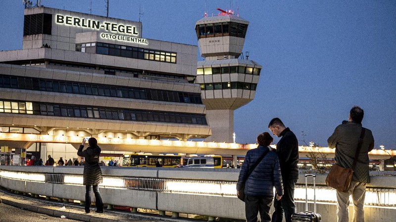 Spectators watch an Air France plane bound for Paris' Charles de Gaulle (CDG) airport driving to the runway before the last take-off from Tegel airport in Berlin, Germany, Sunday, Nov. 8, 2020. Drab and outdated but beloved for its convenience and quirky hexagonal design, Berlin's Tegel airport will finally close for good on November 8 after more than 60 years. The former West Berlin hub is being put into retirement to make way for the new Berlin Brandenburg Airport (BER), which finally opened last week after years of embarrassing delays. (John MACDOUGALL / Pool via AP)
