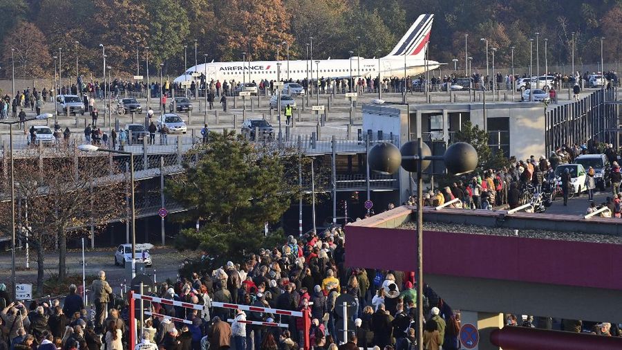 Spectators watch an Air France plane bound for Paris' Charles de Gaulle (CDG) airport driving to the runway before the last take-off from Tegel airport in Berlin, Germany, Sunday, Nov. 8, 2020. Drab and outdated but beloved for its convenience and quirky hexagonal design, Berlin's Tegel airport will finally close for good on November 8 after more than 60 years. The former West Berlin hub is being put into retirement to make way for the new Berlin Brandenburg Airport (BER), which finally opened last week after years of embarrassing delays. (John MACDOUGALL / Pool via AP)