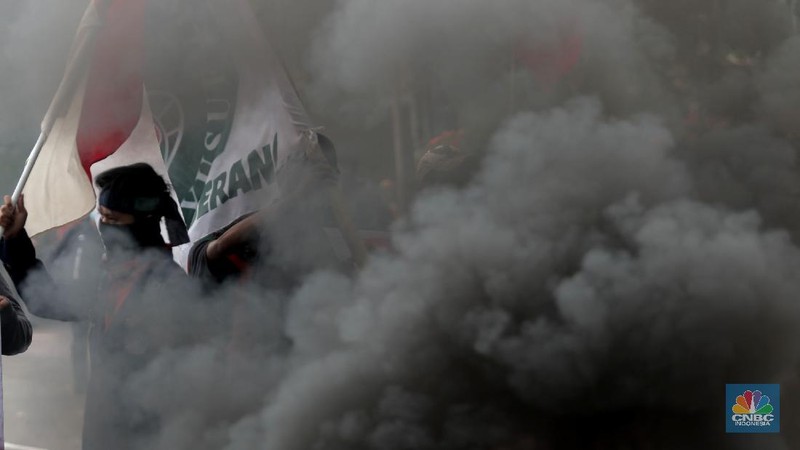Mahasiswa dari berbagai Universitas membakar ban dan berorasi di kawasan Patung Kuda menolak UU Cipta Kerja, Jakarta, Selasa, 10/11. Terlihat massa aksi dari berbagai elemen buruh juga ikut menyalakan flare asap saat berunjuk rasa. Tuntutan yang disuarakan dalam aksi hari ini tetap sama dengan aksi-aksi sebelumnya, yakni meminta Presiden Joko Widodo membatalkan UU Cipta Kerja lewat Perppu. Tuntutan ini tak berubah meski Jokowi telah menandatangani UU yang disusun dengan skema omnibus law itu. (CNBC Indonesia/ Muhammad Sabki)
