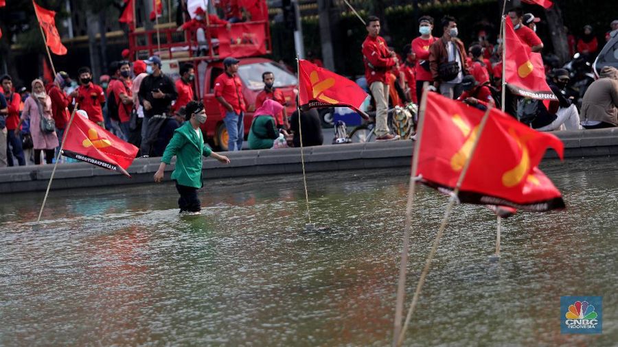 Mahasiswa dari berbagai Universitas membakar ban dan berorasi di kawasan Patung Kuda menolak UU Cipta Kerja, Jakarta, Selasa, 10/11. Terlihat massa aksi dari berbagai elemen buruh juga ikut menyalakan flare asap saat berunjuk rasa. Tuntutan yang disuarakan dalam aksi hari ini tetap sama dengan aksi-aksi sebelumnya, yakni meminta Presiden Joko Widodo membatalkan UU Cipta Kerja lewat Perppu. Tuntutan ini tak berubah meski Jokowi telah menandatangani UU yang disusun dengan skema omnibus law itu. (CNBC Indonesia/ Muhammad Sabki)