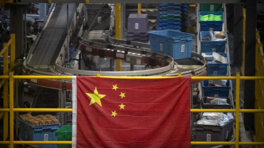 A Chinese flag hangs near an automated parcel handling line at a warehouse for online retailer JD.com in Beijing, Wednesday, Nov. 11, 2020. Chinese consumers are expected to spend tens of billions on everything from fresh food to luxury goods during this year's Singles' Day online shopping festival, as the country recovers from the pandemic. The shopping festival, which is the world's largest and typically begins in November, is an annual extravaganza where China's e-commerce companies offer generous discounts on their platforms. (AP Photo/Mark Schiefelbein)