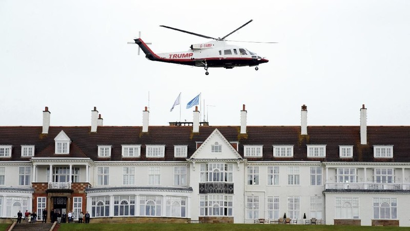 Presidential contender Donald Trump waves to the media after arriving by helicopter during the 1st  first day of the Women's British Open golf championship on the Turnberry golf course in Turnberry, Scotland, Thursday, July 30, 2015. (AP Photo/Scott Heppell)