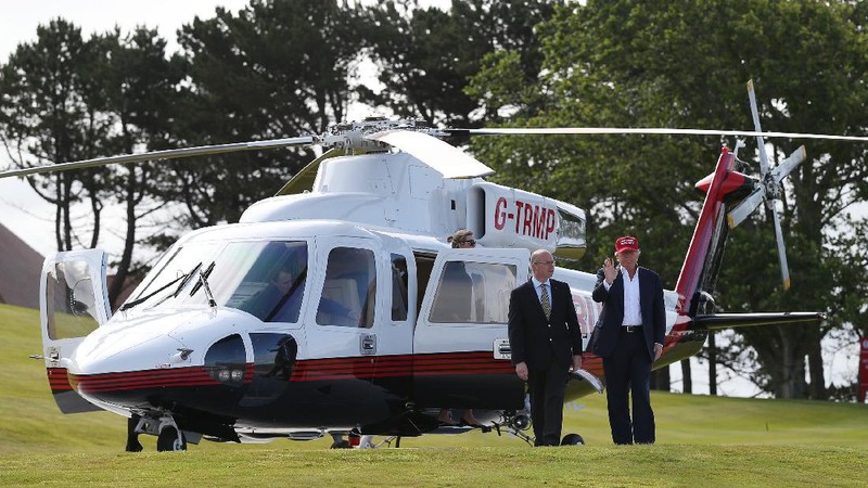 Presidential contender Donald Trump waves to the media after arriving by helicopter during the 1st  first day of the Women's British Open golf championship on the Turnberry golf course in Turnberry, Scotland, Thursday, July 30, 2015. (AP Photo/Scott Heppell)