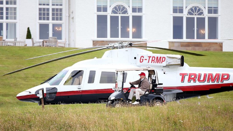 Presidential contender Donald Trump waves to the media after arriving by helicopter during the 1st  first day of the Women's British Open golf championship on the Turnberry golf course in Turnberry, Scotland, Thursday, July 30, 2015. (AP Photo/Scott Heppell)
