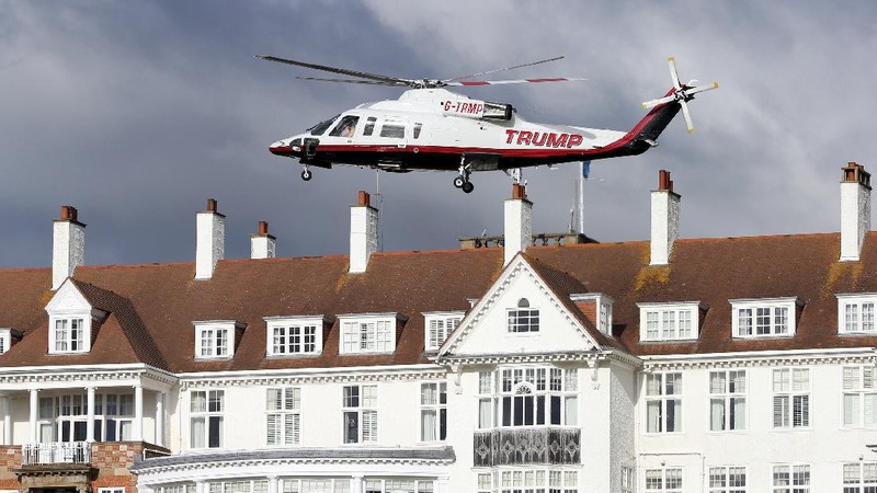 Presidential contender Donald Trump waves to the media after arriving by helicopter during the 1st  first day of the Women's British Open golf championship on the Turnberry golf course in Turnberry, Scotland, Thursday, July 30, 2015. (AP Photo/Scott Heppell)