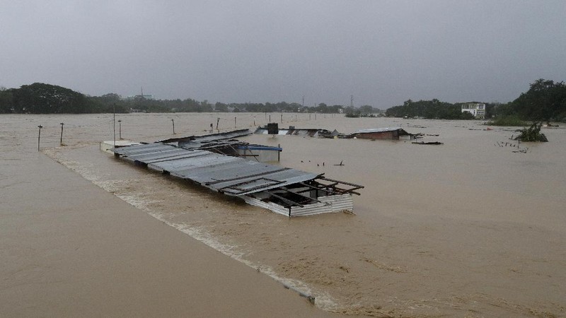 Submerged structures are seen at a swollen river as floods continue to rise in Marikina, Philippines due to Typhoon Vamco on Thursday, Nov. 12, 2020. A typhoon swelled rivers and flooded low-lying areas as it passed over the storm-battered northeast Philippines, where rescuers were deployed early Thursday to help people flee the rising waters.(AP Photo/Aaron Favila)